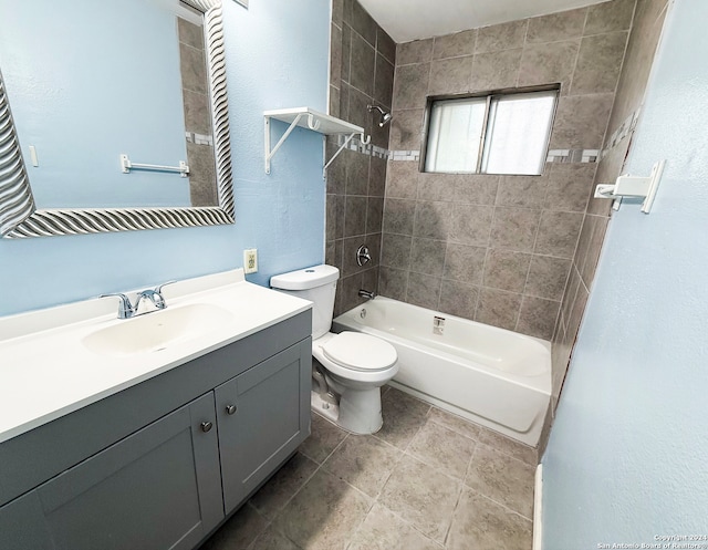 full bathroom featuring vanity, tile patterned floors, toilet, and tiled shower / bath