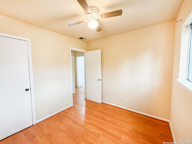 unfurnished bedroom with ceiling fan and light wood-type flooring