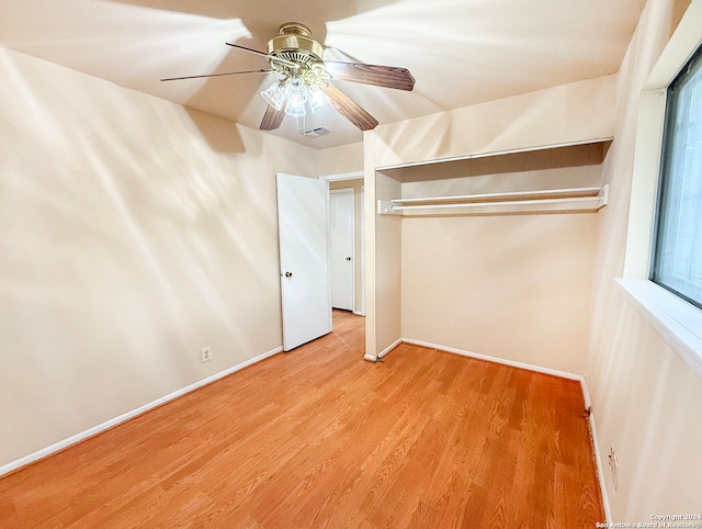 unfurnished bedroom featuring a closet, light wood-type flooring, multiple windows, and ceiling fan