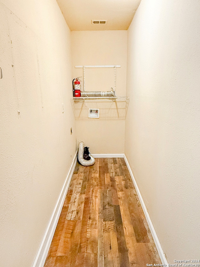 washroom with wood-type flooring, hookup for a washing machine, and electric dryer hookup