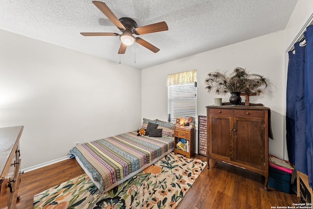 bedroom featuring a textured ceiling, ceiling fan, and dark hardwood / wood-style floors