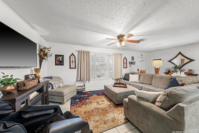 living room featuring ceiling fan, light tile patterned flooring, and a textured ceiling