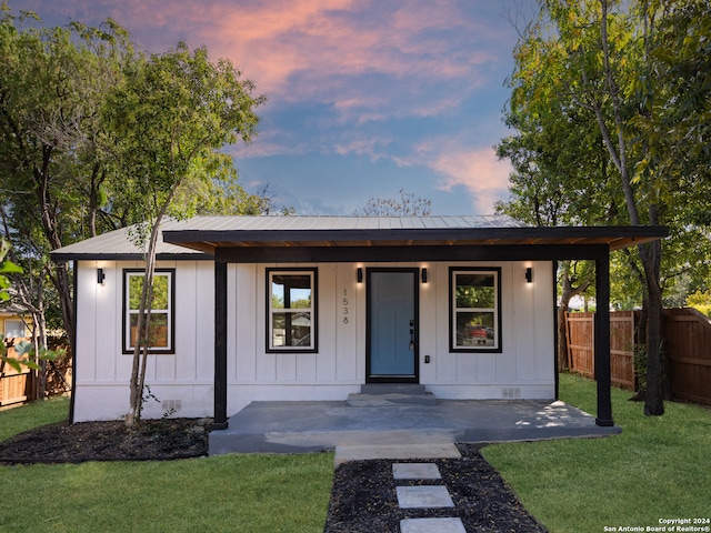 ranch-style house with a yard and covered porch