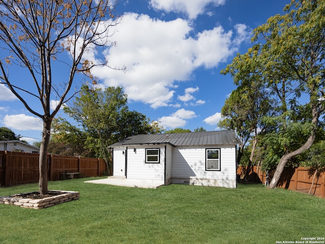 rear view of property with a lawn and a patio