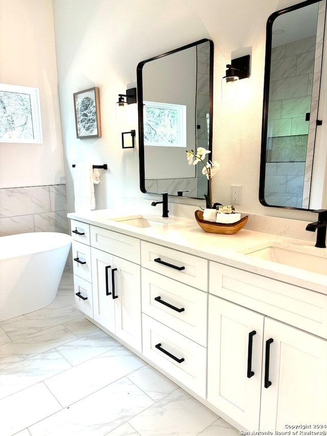 bathroom with a bathtub, vanity, tile walls, and a healthy amount of sunlight