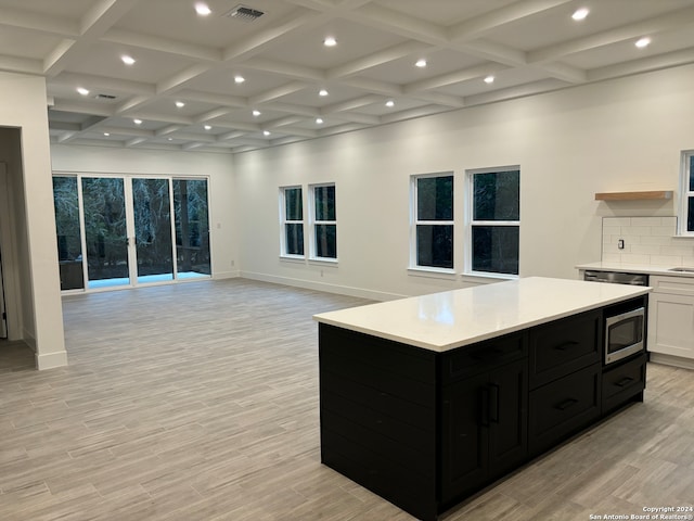 kitchen featuring a center island, white cabinets, light hardwood / wood-style flooring, tasteful backsplash, and appliances with stainless steel finishes