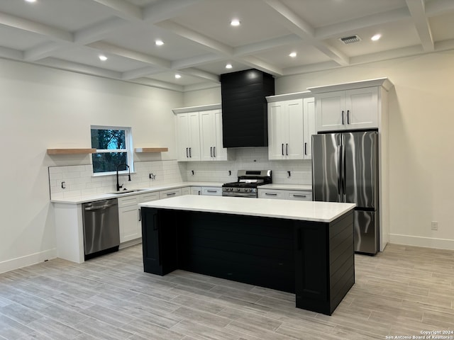 kitchen featuring stainless steel appliances, light hardwood / wood-style floors, sink, a kitchen island, and white cabinets