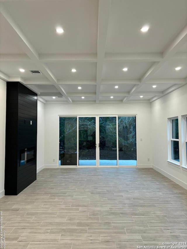 unfurnished room featuring light hardwood / wood-style floors, beam ceiling, and coffered ceiling