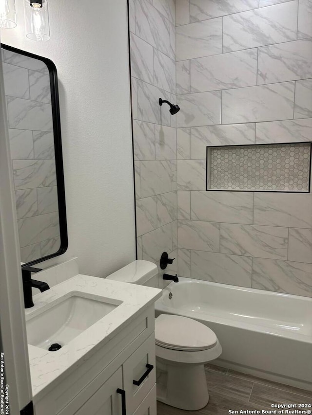 full bathroom with vanity, toilet, and tiled shower / bath