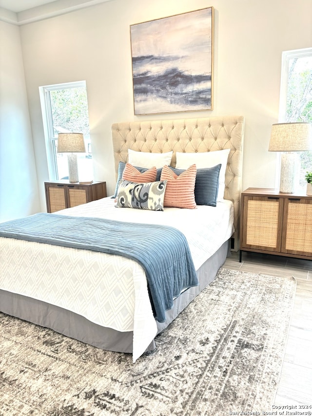 bedroom with light hardwood / wood-style flooring and multiple windows