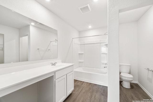 full bathroom featuring toilet, vanity, hardwood / wood-style floors, and bathing tub / shower combination