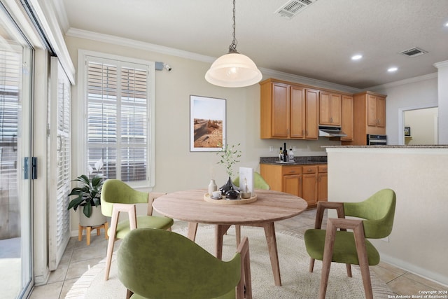 dining space featuring ornamental molding, a textured ceiling, and light tile patterned floors