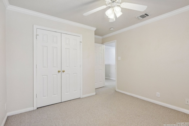 unfurnished bedroom with ornamental molding, light carpet, ceiling fan, and a closet