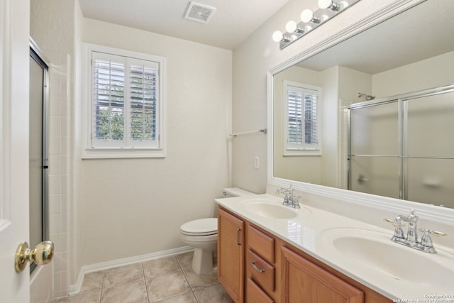 bathroom featuring a wealth of natural light, vanity, toilet, and a shower with door