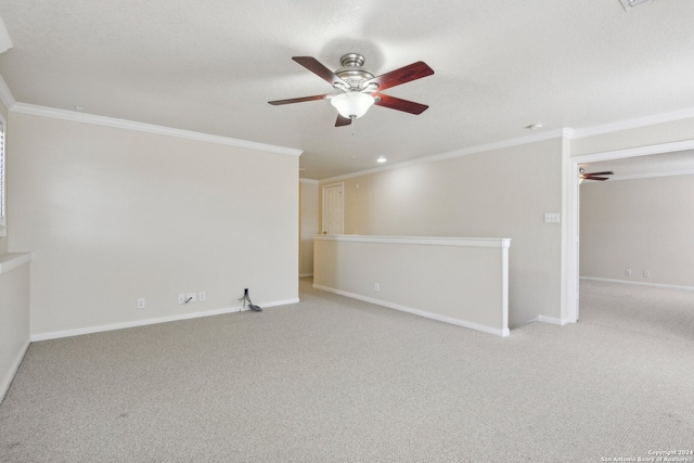 spare room featuring ceiling fan, crown molding, and light colored carpet