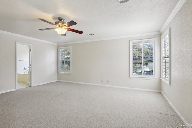 empty room with a textured ceiling, light colored carpet, ceiling fan, and crown molding