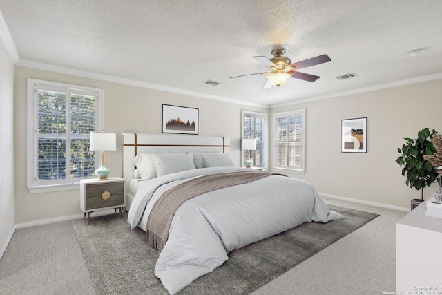 carpeted bedroom featuring a textured ceiling, multiple windows, and ceiling fan