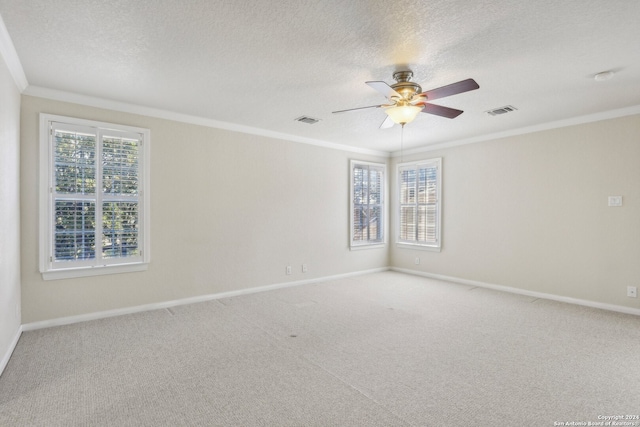 carpeted empty room with a wealth of natural light, ceiling fan, a textured ceiling, and crown molding