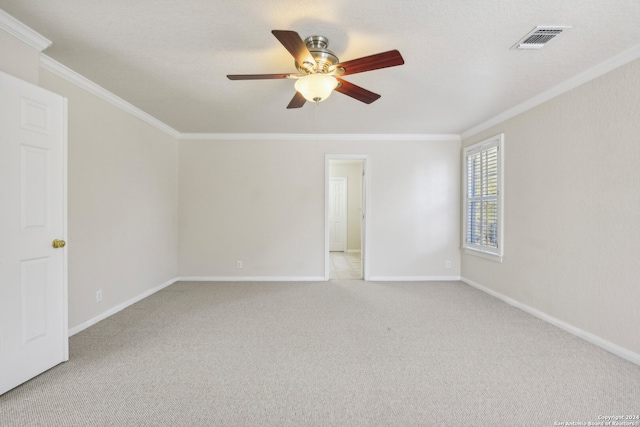 carpeted empty room featuring ceiling fan and crown molding