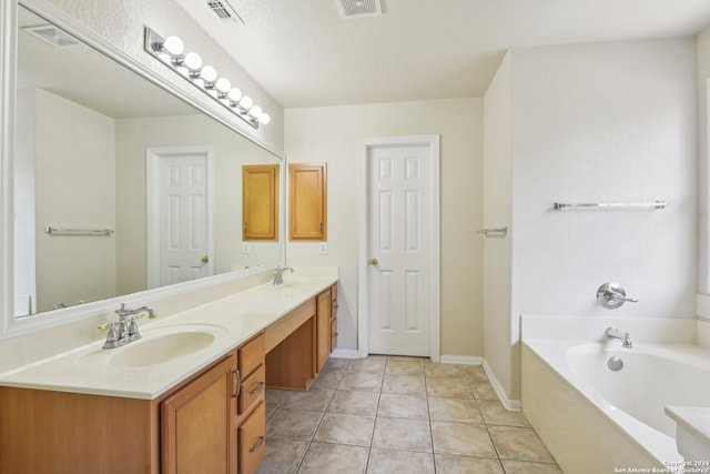 bathroom with a washtub, vanity, a textured ceiling, and tile patterned floors