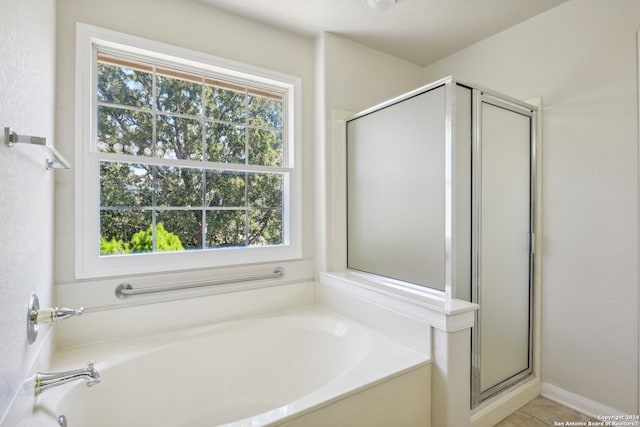 bathroom with shower with separate bathtub and plenty of natural light