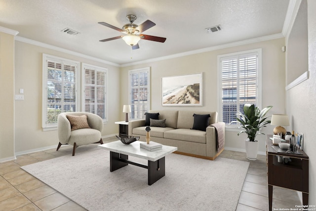 tiled living room featuring ceiling fan, a textured ceiling, and ornamental molding