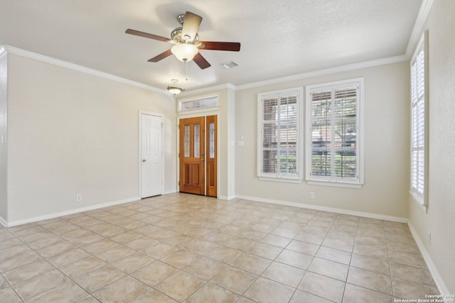 tiled empty room with ceiling fan, a textured ceiling, and ornamental molding