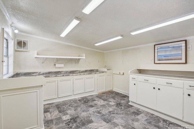 24434 Brazos Stage, San Antonio, TX 78255 - kitchen with open shelves, a textured ceiling, white cabinetry, ornamental molding, and lofted ceiling