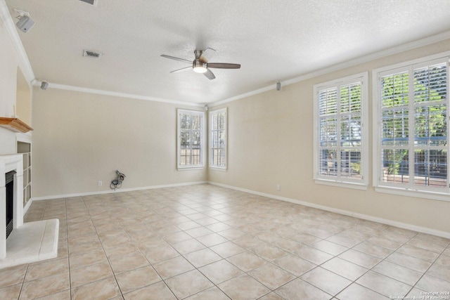 24434 Brazos Stage, San Antonio, TX 78255 - unfurnished living room featuring crown molding, ceiling fan, a textured ceiling, light tile patterned flooring, and a fireplace with raised hearth