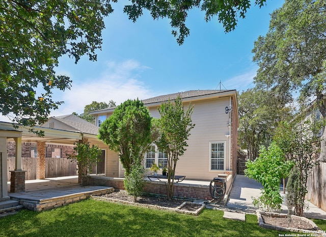 back of house featuring a patio area and a lawn