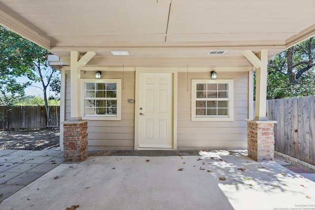 view of exterior entry with a patio