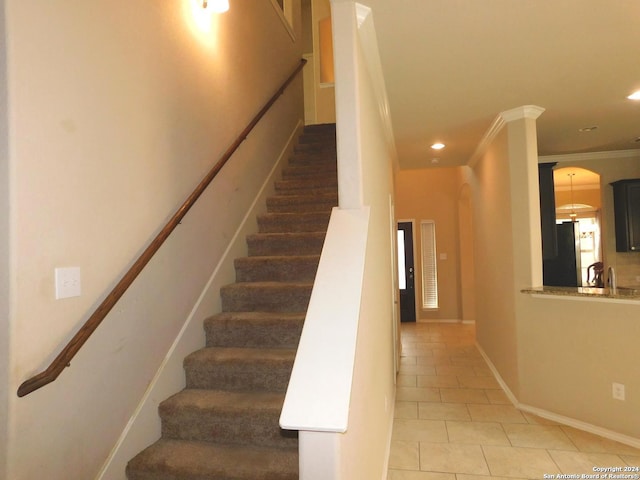 stairs with tile patterned floors and ornamental molding