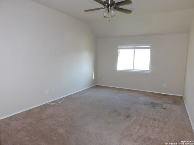 unfurnished room featuring light carpet, vaulted ceiling, and ceiling fan