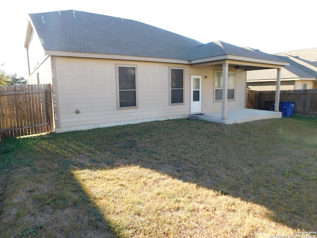 rear view of house featuring a lawn and a patio