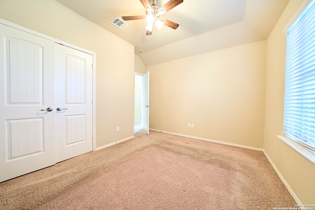 unfurnished bedroom featuring ceiling fan, a closet, carpet floors, and multiple windows