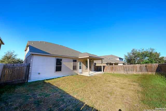 rear view of property featuring a patio area and a yard