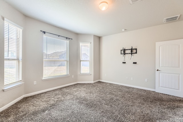 empty room featuring carpet and a textured ceiling