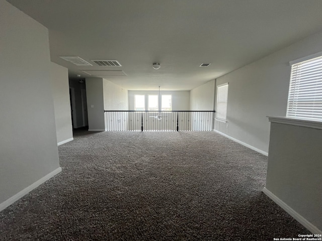 unfurnished room featuring carpet flooring and a notable chandelier