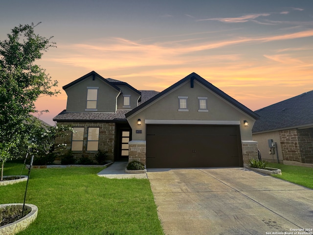 view of front of house featuring a garage and a yard