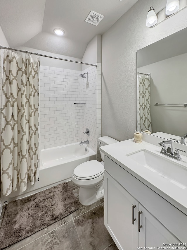 full bathroom featuring shower / bath combination with curtain, vanity, vaulted ceiling, tile patterned flooring, and toilet