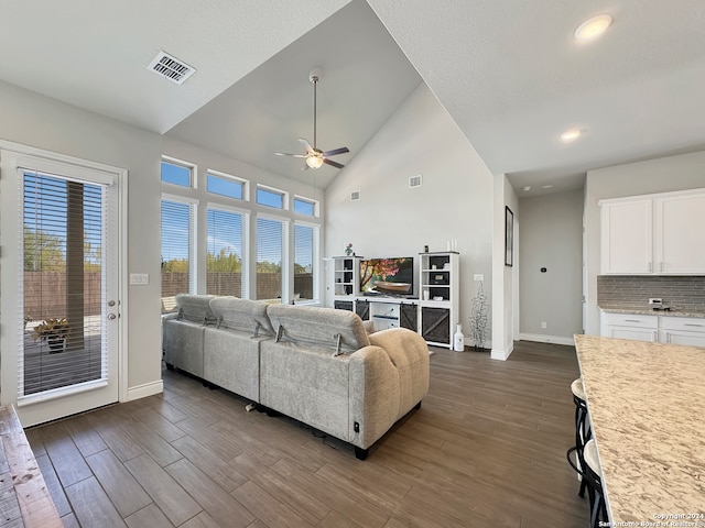 living room with ceiling fan, dark hardwood / wood-style floors, a healthy amount of sunlight, and high vaulted ceiling