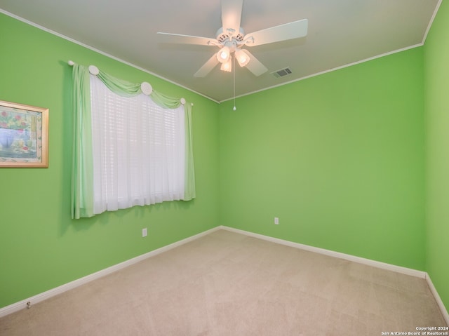 empty room with ceiling fan, light carpet, and crown molding