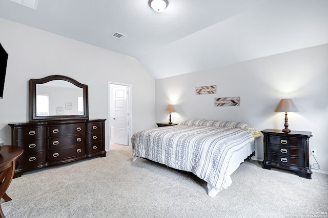 bedroom featuring lofted ceiling and light carpet