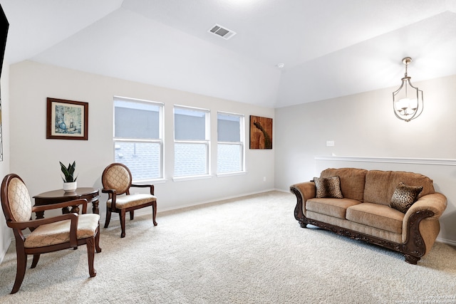 carpeted living room with lofted ceiling and an inviting chandelier