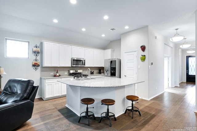 kitchen featuring dark wood-type flooring, appliances with stainless steel finishes, an island with sink, and white cabinets