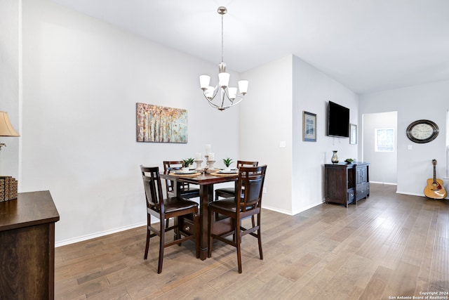 dining area featuring hardwood / wood-style flooring and a chandelier