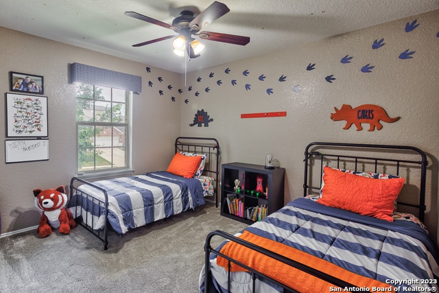 bedroom featuring a textured ceiling, carpet floors, and ceiling fan