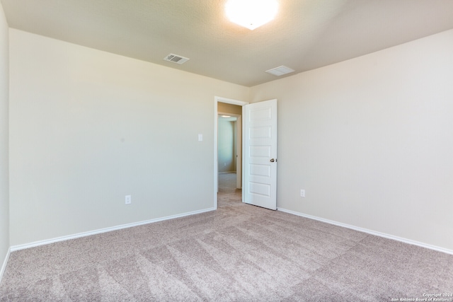 carpeted spare room featuring a textured ceiling