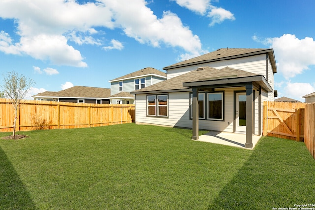 back of property featuring a patio and a yard