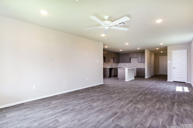 unfurnished living room with dark hardwood / wood-style flooring and ceiling fan